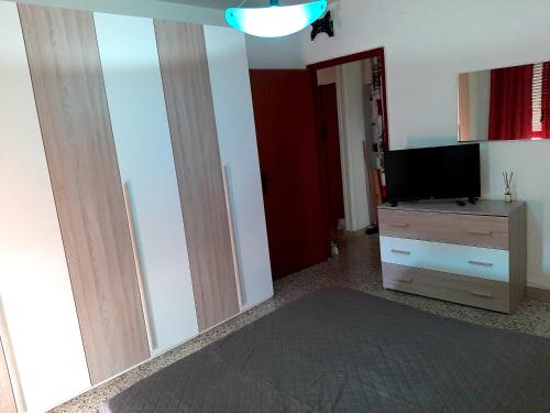 uma sala de estar com uma televisão de ecrã plano e uma cómoda em Casa Rosa em Crispiano