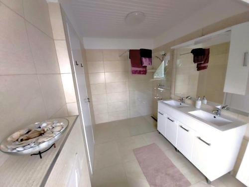 a white bathroom with a sink and a toilet at Hangulat Vendégház / Apartman in Harkány