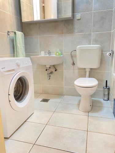 a bathroom with a washing machine and a sink at Apartman Krešo in Makarska