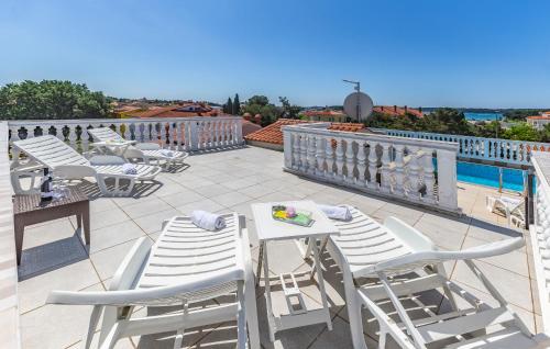 a row of white chairs and tables on a patio at Villa San Rocco Bed & Breakfast in Medulin