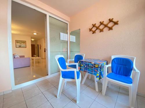 a dining room with blue chairs and a table at Apartman Krešo in Makarska