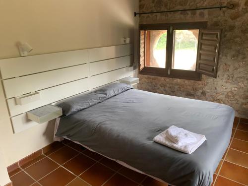 1 cama en un dormitorio con ventana en Castillo con piscina en plena Sierra Calderona, en Segorbe