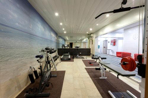 a gym with a row of treadmills and machines at Hotel Horitzó by Pierre & Vacances in Blanes