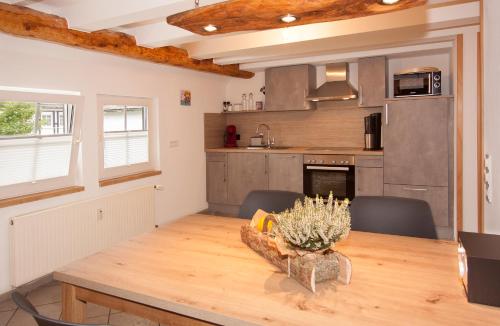 a kitchen and dining room with a wooden table at Landhotel Voss im TalVital in Saalhausen
