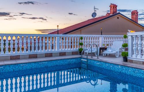 a house with a swimming pool and a white fence at Villa San Rocco Bed & Breakfast in Medulin