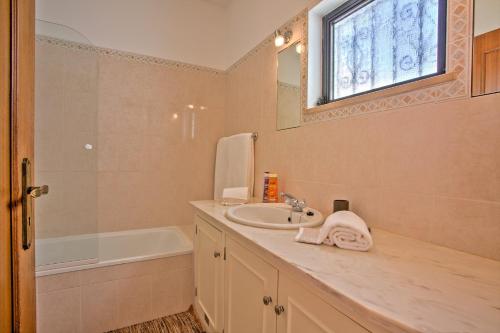 a bathroom with a sink and a bath tub at Villa Candida by Villa Plus in Vale do Lobo