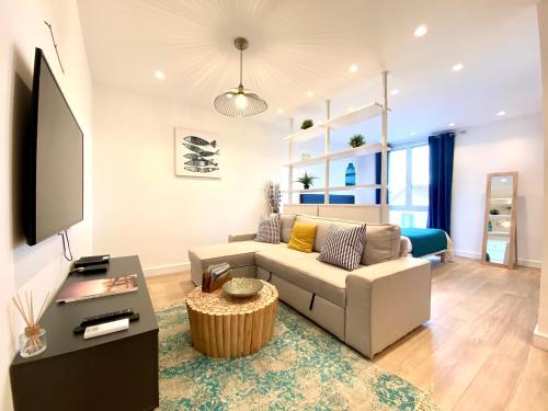 サントロペにあるMagnifique Studio à deux pas du port de Saint-Tropezのソファとテレビのあるリビングルーム