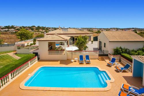 a villa with a swimming pool in front of a house at Villa Arvela by Villa Plus in Galé