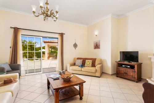 a living room with a couch and a tv at Villa Arvela by Villa Plus in Galé