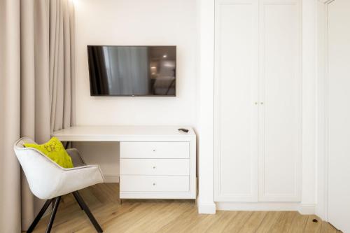 a white desk in a room with a tv on a wall at Maritime Residence in Międzyzdroje