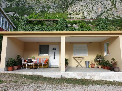 a house with a patio with a table and chairs at Apartment Jelena in Kotor