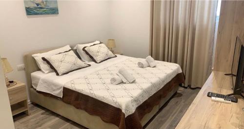 a bedroom with a bed with white sheets and pillows at Deni's Hotel in Sarandë