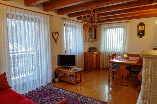 a living room with a couch and a desk with a television at Casa Francesca - Relax nel cuore delle Dolomiti in Pieve di Cadore