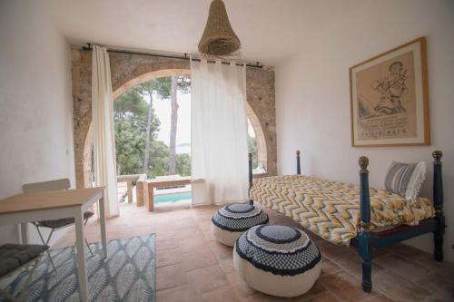 a bedroom with a bed and a table and a window at Villa Dora (Only adults) in Jávea
