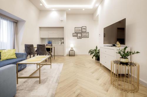 a living room with a blue couch and a tv at Maritime Residence in Międzyzdroje