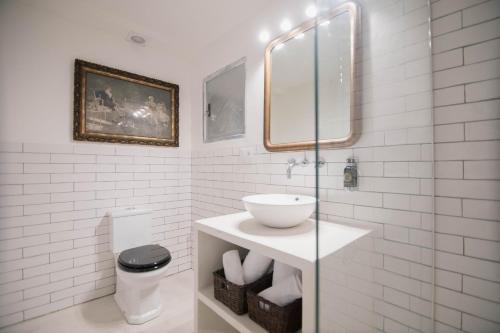 a white bathroom with a sink and a toilet at Villa Dora (Only adults) in Jávea