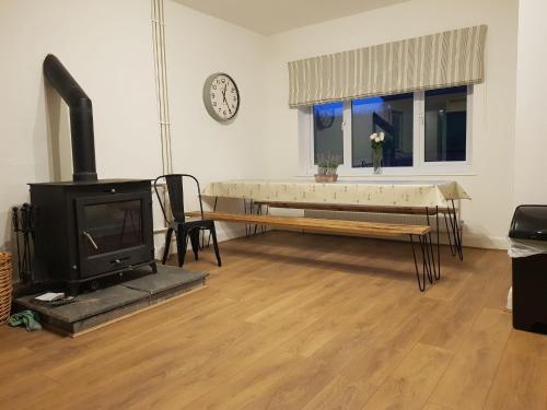 a living room with a fireplace and a table at Hastings Retreat Rural barn conversions with Private Lake in Ashby de la Zouch