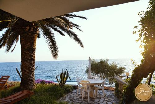 a table and chairs with the ocean in the background at Resort Stikovic in Dobra Voda