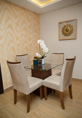 a dining room with a glass table and chairs at The Cabin Hotel in Accra
