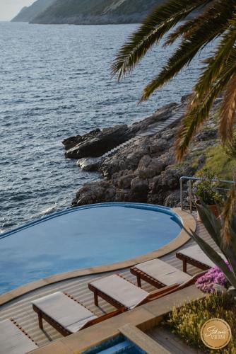a swimming pool with lounge chairs next to the water at Resort Stikovic in Dobra Voda