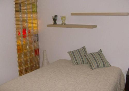 a bedroom with a bed with two pillows on it at Casa da Praia Apartment - Alvor Beach in Alvor