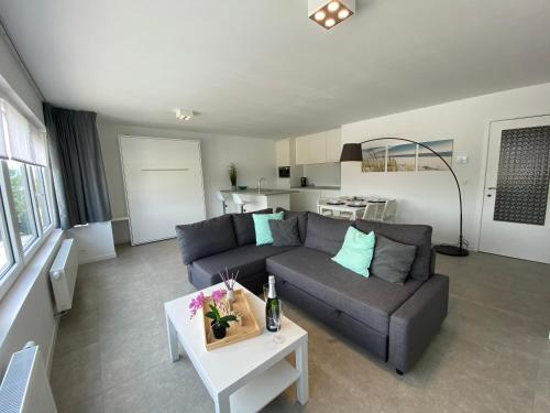 a living room with a couch and a table at Residentie Duinenzucht - Appartement Laure I Studio Lynne in Bredene