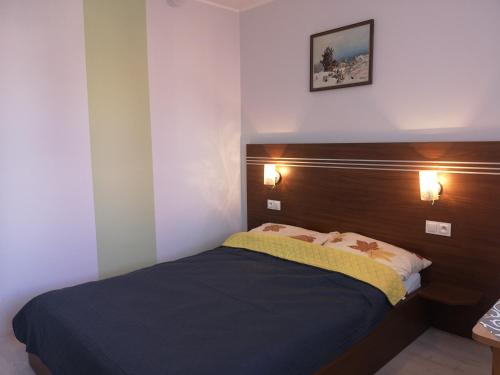 a bedroom with a bed with a wooden headboard at Róża Wiatrów 2 Władysławowo in Władysławowo