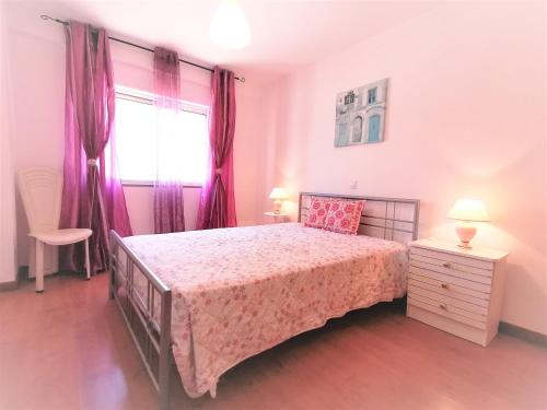 um quarto com uma cama e uma janela com cortinas roxas em Encosta da Marina Beach Apartment em Portimão