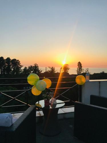a view of the sunset from a balcony with a table at Wonderland in Chakvi