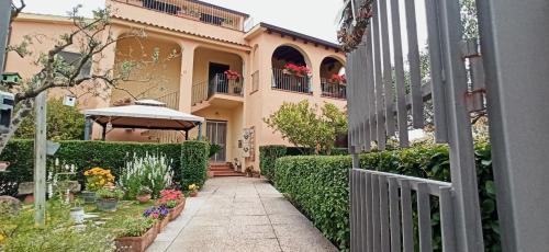 una pasarela que conduce a una casa con flores y plantas en B&B Casa Piras en Barùmini