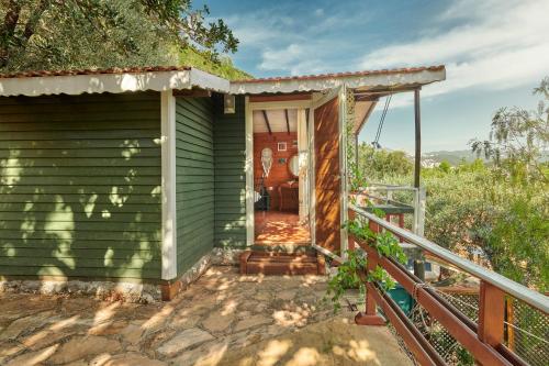 an outside view of a green house with a porch at Can Mocamp in Kas