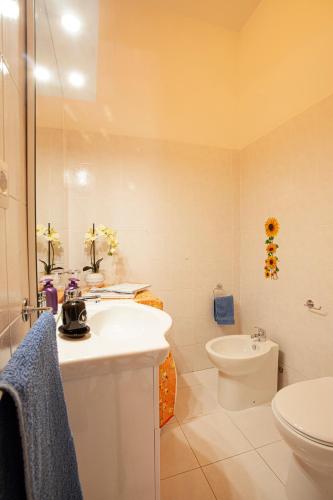 a white bathroom with a sink and a toilet at Arcobaleno 1 in Villasimius
