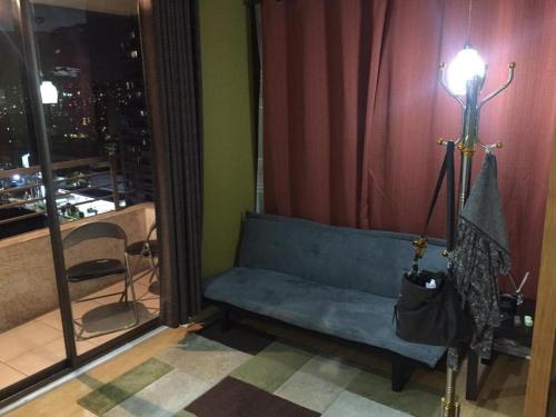 a living room with a blue couch and a mirror at Apartamento Metro Santa Lucia, Santiago Centro in Santiago