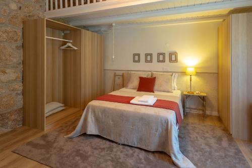 1 dormitorio con 1 cama grande con almohadas rojas en Casa Tarrio - Casa Privada com 3 Quartos e Piscina en Braga