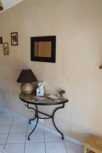 a table with a lamp on it in a room at A L'Orée du Bois in Rétaud
