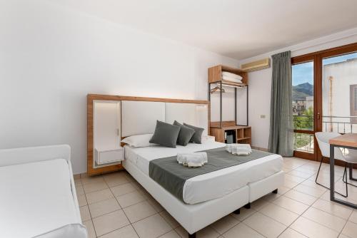 a bedroom with a large bed and a balcony at Hotel Al Paradise in San Vito lo Capo
