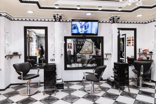 a hair salon with black chairs and a mirror at Viktoriya Family Hotel Restaurant complex in Kyiv