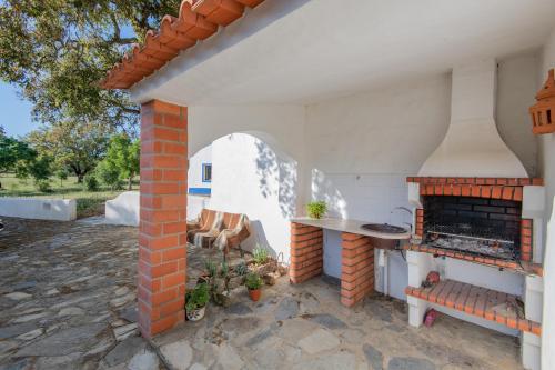 an outdoor kitchen with an outdoor oven in a patio at MyStay - Herdade do Vale da Abelheira in Grândola