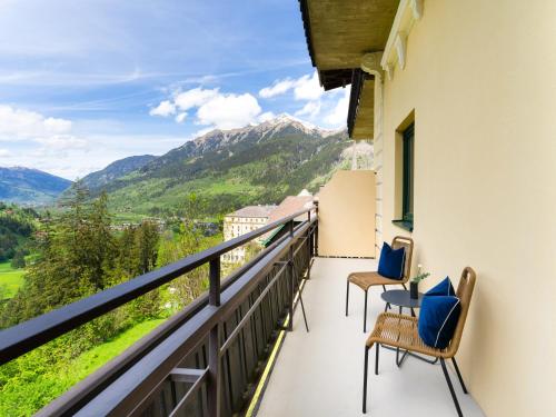 a balcony with chairs and a view of mountains at Das Schider - Boutique Apart-Hotel in Bad Gastein
