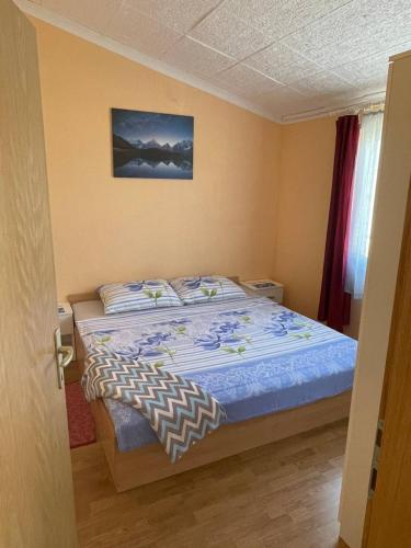 a bedroom with a bed with a blue comforter at Apartment Zdenka in Vir