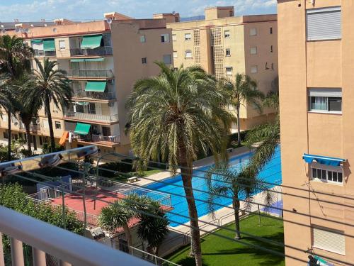 una vista aérea de una piscina con palmeras y edificios en Casa Dona, en Playa de Pobla de Farnals