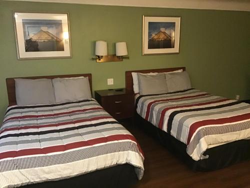 two beds in a room with green walls at Bellevue Hotel and Suites in Bellevue