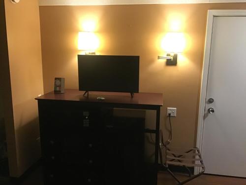 a desk with a television and two lights on a wall at Bellevue Hotel and Suites in Bellevue
