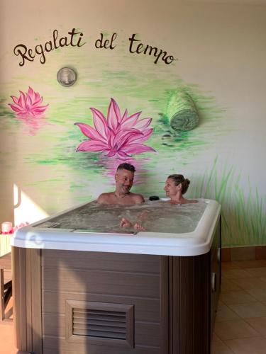 a man and a woman in a bathtub with a sign at B&B Beauty House in Cesena