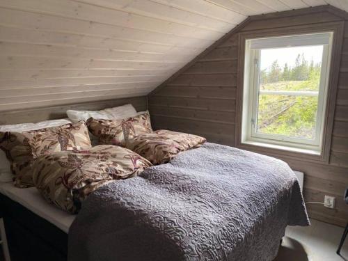 Bett in einem Zimmer mit Fenster in der Unterkunft Ski in-out at Lifjell-Mountain cabin with majestic views close to Bø Sommarand in Bø