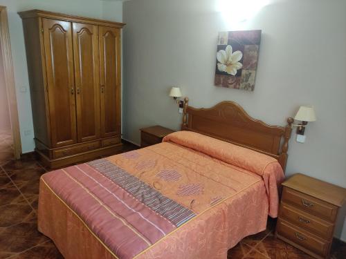 a bedroom with a bed and a wooden cabinet at Hotel Peñagrande in Cangas del Narcea