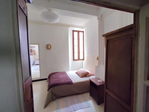 ein kleines Schlafzimmer mit einem Bett und einem Fenster in der Unterkunft Charmant appartement dans La Catiche de Loutre in Sauve