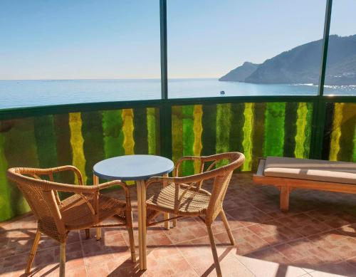 a table and chairs on a balcony with a view of the ocean at KAKTUS Hotel Kaktus Albir in Albir
