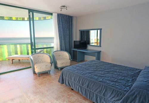 a bedroom with a bed and a television and a balcony at KAKTUS Hotel Kaktus Albir in Albir