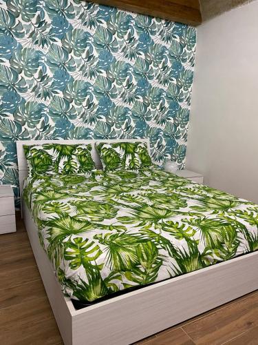 a bedroom with a bed with a green and white bedspread at Tropical House in Mola di Bari